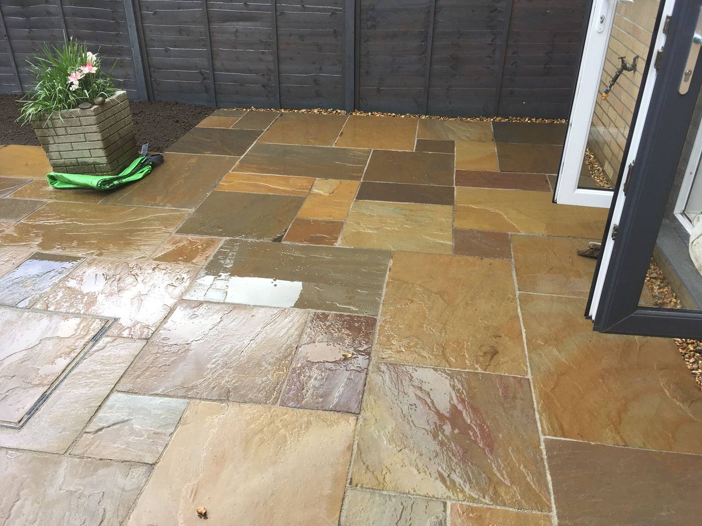 The finished job: an Indian sandstone patio, wet after rain